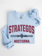folded light blue gildan sweatshirt flat lay with Strategos Nocturna bonding trials fantasy wolf graphic