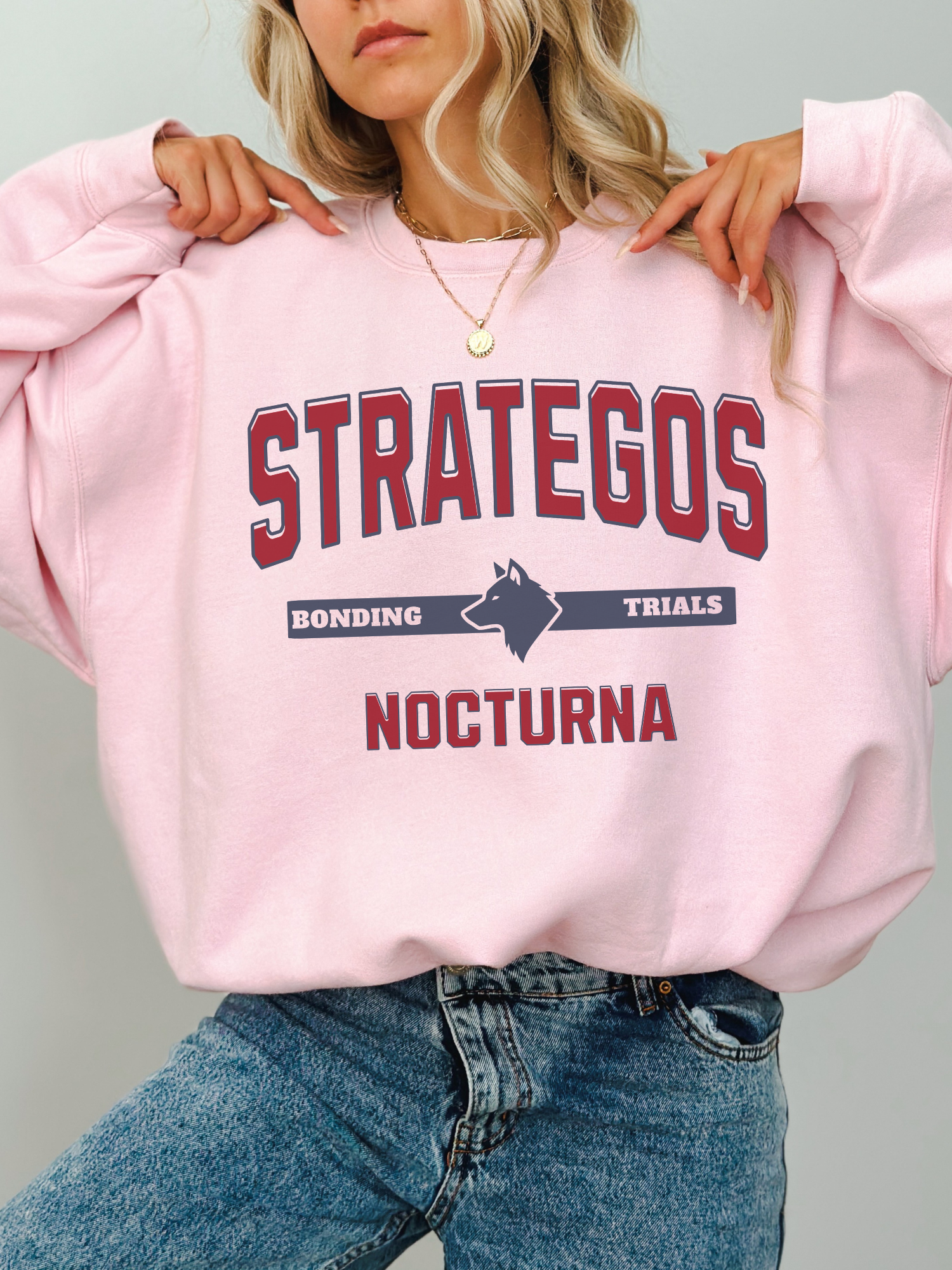 light pink gildan sweatshirt with Strategos Nocturna fantasy academy inspired bonding trials design