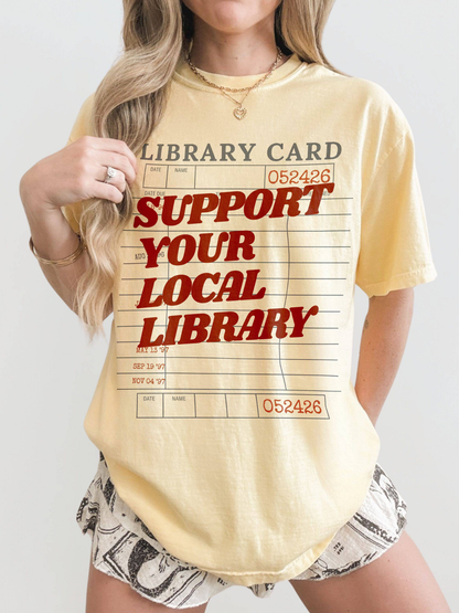 woman wearing butter support your local library t shirt with vintage library card graphic styled casually for book lovers and readers