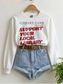 white sweatshirt with support your local library graphic styled with denim shorts and belt on hanger in minimal aesthetic setting