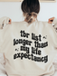 woman in sand sweatshirt with playful bookish quote on the back about her never-ending reading list