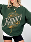 Forest green Kejari Tournament crewneck sweatshirt with gold detailing and sword motif, ideal for fantasy book fans and cozy cold-weather layering.
