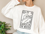 white sweatshirt with black tarot-style illustration of hand holding pencil and text The Writer