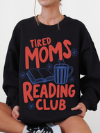 woman wearing black tired moms reading club sweatshirt with retro book lover design featuring coffee cup open book and flowers