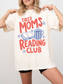 woman wearing oversized natural cream tired moms reading club graphic t shirt with retro typography coffee mug and open book artwork