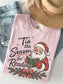 Blossom Comfort Colors shirt featuring a vintage Santa reading a green book with Tis the Season for Reading text, evergreen branches, red berries, festive bow and gold stars, Christmas book lover shirt
