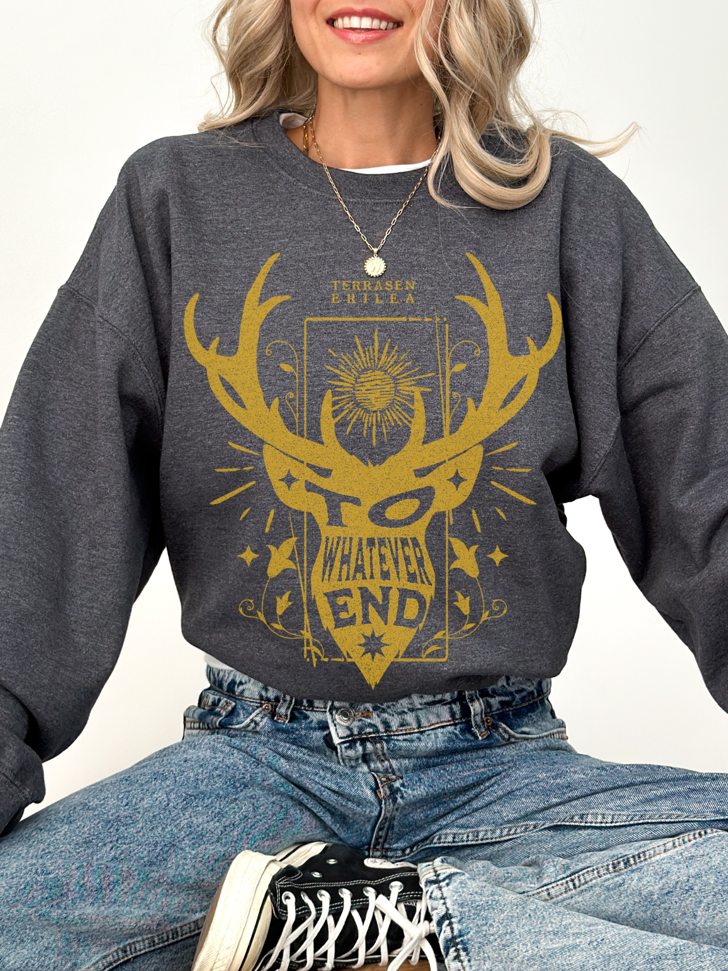 woman in dark heather grey sweatshirt with gold fantasy design and “To Whatever End” quote from the Throne of Glass series

