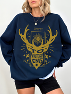 woman wearing navy blue sweatshirt with gold Terrasen crest and the quote “To Whatever End” from Erilea lore

