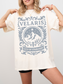 woman wearing a white t-shirt in an elevator with light grey Velaris City of Starlight design and mountain scene