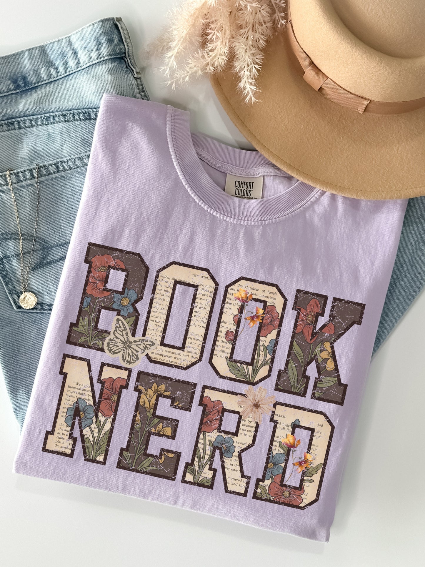 Orchid Comfort Colors shirt featuring a vintage Book Nerd graphic filled with book pages, flowers and butterflies, aesthetic bookish t shirt and gift for readers