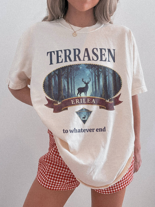 Model wearing a vintage Terrasen Comfort Colors shirt in a neutral tone featuring a forest stag illustration, styled with red gingham shorts against a minimal indoor background