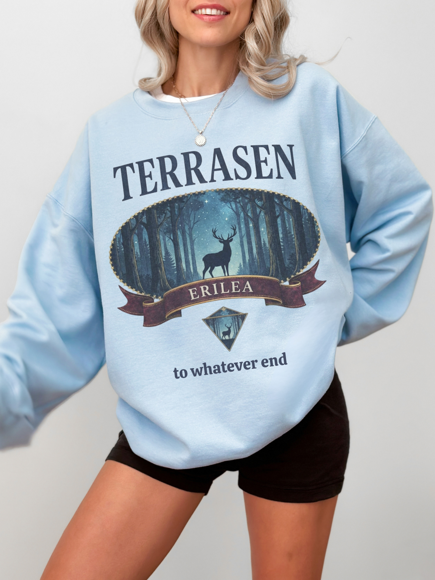 woman wearing a light blue vintage terrasen sweatshirt with fantasy book inspired crest artwork