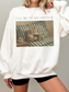 White oversized sweatshirt featuring Ill be in my office text above a vintage style cat reading a book in bed with a tea cup, styled casually with biker shorts. Cozy book lover sweatshirt for readers, introverts, and cat lovers.